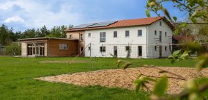 Gästehaus Strohtel von der Rückseite. Ein Vlleyballfeld im Vordergrund.