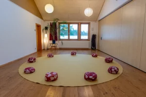 Kleiner Seminarraum mit Teppich und Sitzkissen auf dem Boden